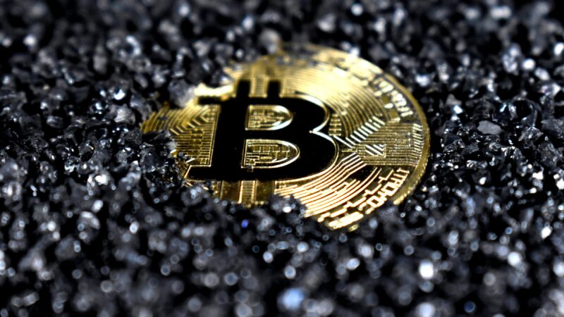 Bitcoin logo hidden in black sand