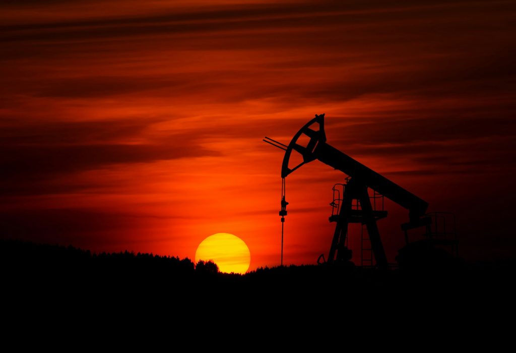 Oil equipment against a red backdrop representing oil market outlook.