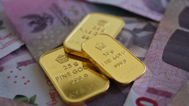 Gold buying with gold bars placed over currency notes, highlighting Central bank gold demand, US dollar weakness, Gold Demand, and Dollar purchasing power.