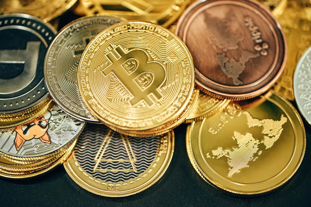 A close-up of Bitcoin and other cryptocurrency coins, representing the Bitcoin rally, ZCash price, Cardano price, XRP price, and rising Crypto market cap.