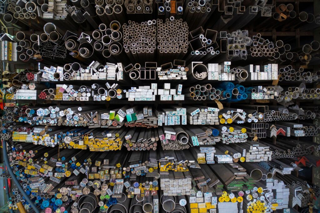Metal pipes and bars stacked in a warehouse, illustrating the World Bank metals forecast, rising gold demand, gold price trends, and gold ETF inflows amid changing precious metals market conditions.
